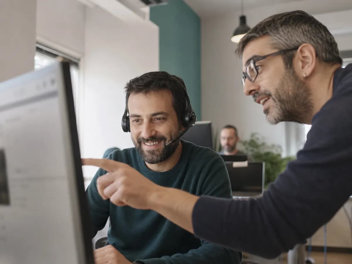 Due sviluppatori di Ambulatorio Facile al lavoro mentre uno risponde al telefono a uno studio medico